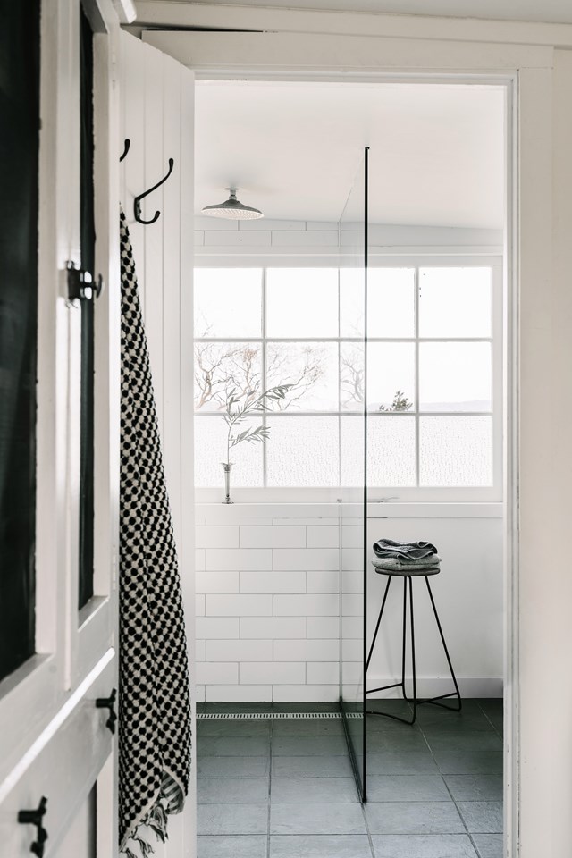 The addition of crisp white subway tiles brings [this seaside cottage bathroom](https://www.homestolove.com.au/the-burrows-swansea-tasmania-21597|target="_blank") up to date, allowing the original textured glass windows and snug proportions to be the hero. Vintage towel hooks and an antique stool in black speak to the building's heritage. *Photo: Marnie Hawson / Stylist: Lynda Gardener, Belle Hemming / Story: Country Style*