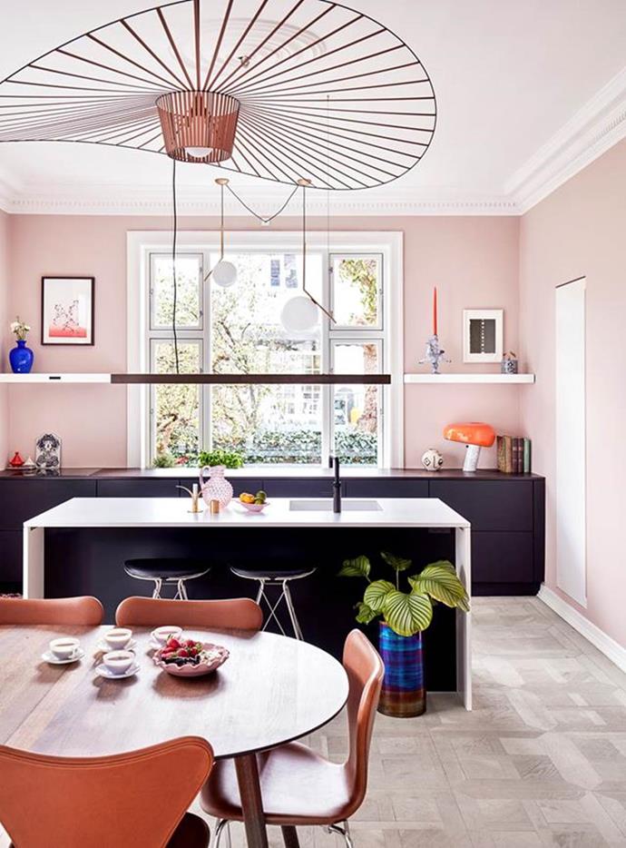 A carefully chosen colour palette of pale pink, orange and deep blue are splashed throughout this charming kitchen in an [eclectic apartment](https://www.homestolove.com.au/colourful-eclectic-style-apartment-19184|target="_blank") in Frederiksberg, Denmark. The kitchen offers a wealth of colour, with black cabinetry and a low-hanging lamp to create contrast.