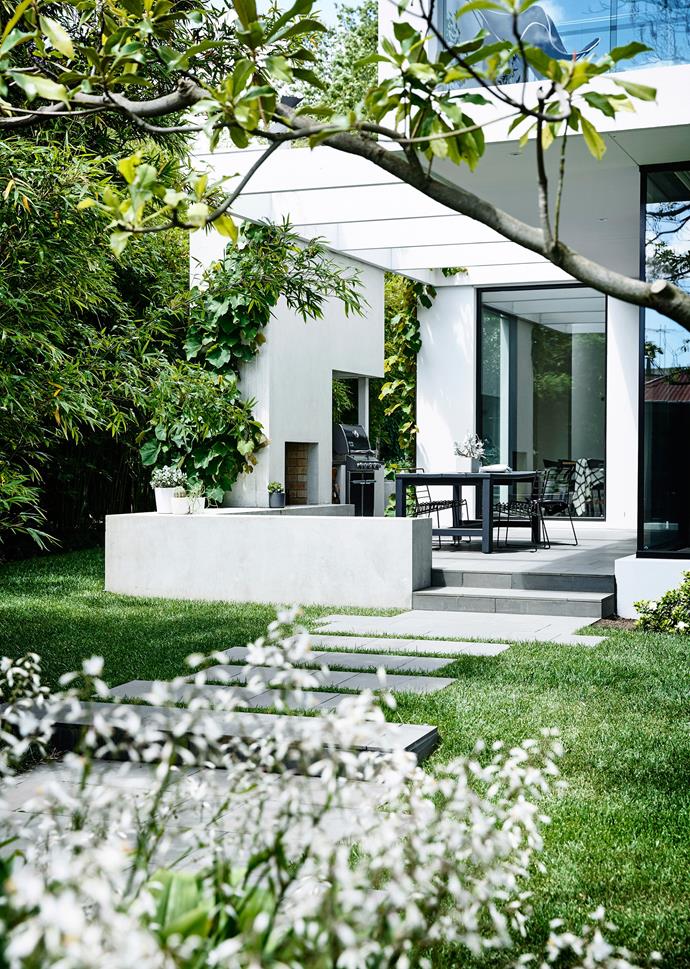 The rear garden of this [Victorian Melbourne home](https://www.homestolove.com.au/a-garden-of-contrasts-that-works-harmoniously-3105|target="_blank") is streamlined and geometric with lawn at its centre, with a casual paved path leading to the entertaining section. "We wanted a traditional garden out the front, but relaxed and meandering, not a stiff Victorian garden with hedging," said the owner.