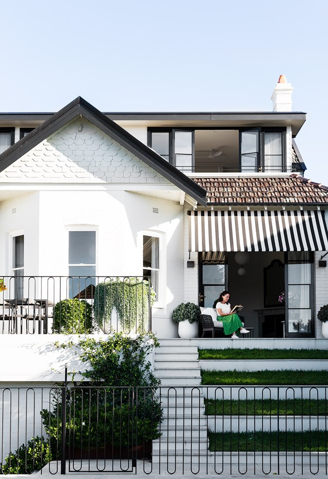 Dappled leadlighting, shingled roofing and a chic, elegant exterior were enough to make MJ fall in love with [this Federation home](https://www.homestolove.com.au/heritage-family-home-sydney-21847|target="_blank"), even before she took a single step inside. Shaded by a black and white striped awning that echoes the exterior of the house, the outdoor terrace boasts overflowing planters and invites exploration of the pool and garden beyond, connecting indoors and out.