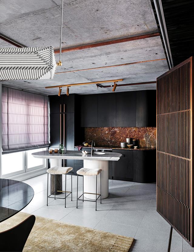 Everything in this [Sydney apartment](https://www.homestolove.com.au/sydney-penthouse-apartment-by-amber-road-19349|target="_blank")has a dual purpose, thanks to Amber Road's clever design. The kitchen is a standout, allowing access to the balcony around a sculptural island.