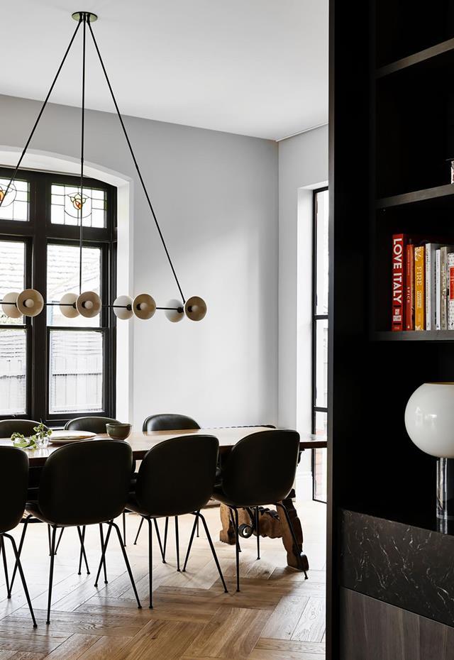 Influences from bygone eras and forgotten trades form lasting connections in this [early 1900s home](https://www.homestolove.com.au/early-1900s-house-revamped-monochrome-palette-21872|target="_blank"), deftly unified by Fiona Austin of Austin Design Associates, via a sophisticated monochrome palette. The dining area includes an Edwardian leadlight window. An Apparatus 'Trapeze 10' pendant light from Criteria illuminates the table and chairs.