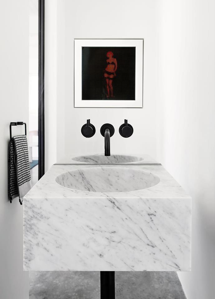 Yummy Mummy by Liu Dao is reflected in the mirrored wall of the powder room, where 'Industrica' tapware from Brodware is paired with a Salvatori 'Alfeo' basin in Bianco Carrara marble from Boffi. Hand towel from Oliver Thom.