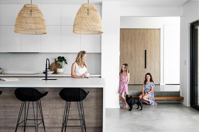 "We do a lot of cooking at home, so I wanted a big cooking and prep area," says Sarah (below, with Mylee, Chloe and French Bulldog Leo). Clear, uncluttered Caesarstone benchtops in Cloudburst make whipping up meals and entertaining a pleasure, and a pretty timber-centric vignette that includes a bowl by Spotlight adds interest. 'Paradise' pendants from Black Salt Co continues the celebration of raw materials – with a twist. "I specifically chose black cords to match the black [bar stools](https://www.homestolove.com.au/stylish-stools-australia-21664|target="_blank") and black sink and tap," says Sarah, pointing out the 'Angola' bar chair from Uniqwa and Franke Kitchens tapware.