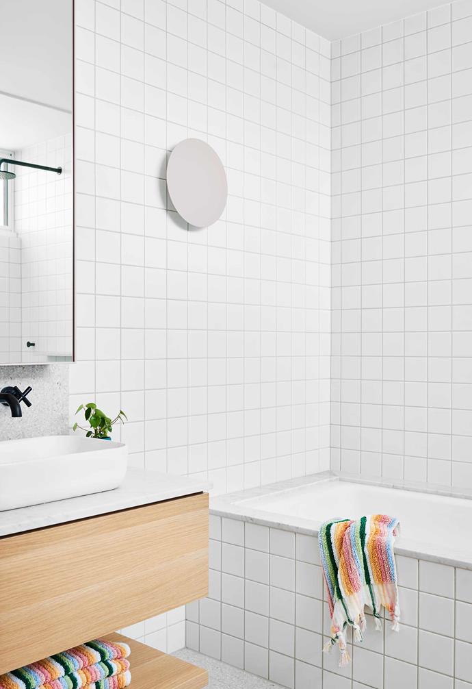 **Girls' bathroom** The mosaic tiles provide a simple backdrop for the Carrara marble benchtop and [Fibonacci Stone](https://www.fibonaccistone.com.au/|target="_blank"|rel="nofollow") terrazzo splashback that's mirrored in the subtle border around the bath. Mirror and vanity, [SCLK](https://sclk.com.au/|target="_blank"|rel="nofollow"). Towels, [Kip & Co](https://kipandco.com.au/|target="_blank"|rel="nofollow").