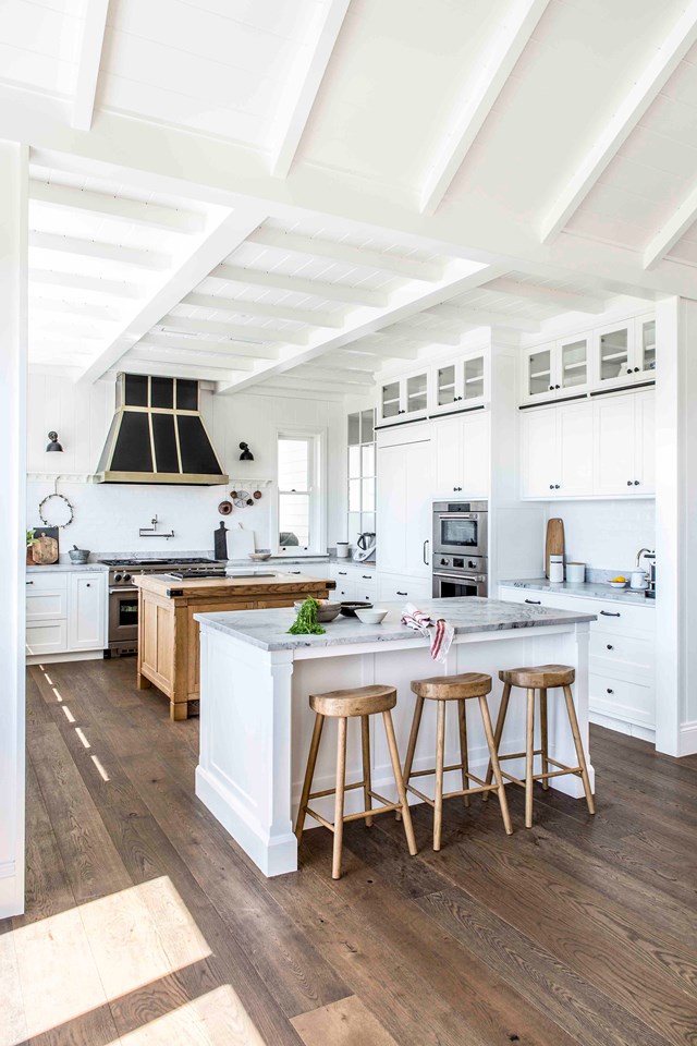 Handles are a feature in [this modern farmhouse kitchen](https://www.homestolove.com.au/modern-farmhouse-southern-highlands-22012|target="_blank") and tie in with accents of the rangehood and timber stools and central workbench.
