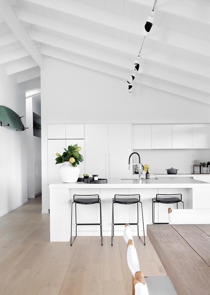 Positioned at the rear of a [breezy coastal home in Queensland](https://www.homestolove.com.au/bright-and-breezy-home-coastal-queensland-22044|target="_blank"), this kitchen allows the owners to stay connected to their family and guests as they prepare meals. The show-stopper is the vaulted ceiling, which further amplifies the generous proportions of the room. Contrast is introduced by the way of black bar stools and tapware. 