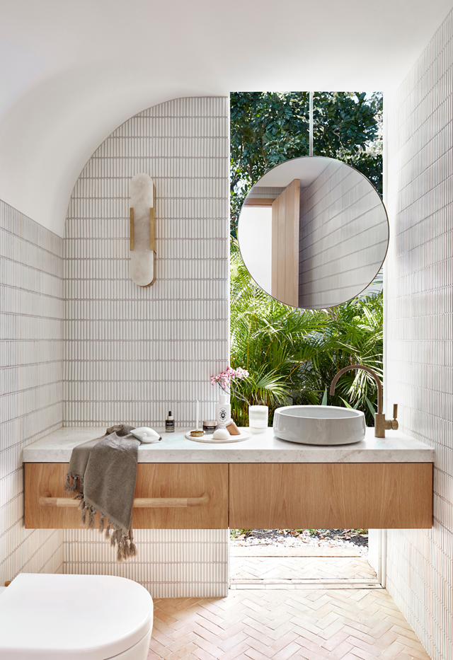 The absence of colour doesn't leave the design wanting in [this cool coastal home](https://www.homestolove.com.au/casual-christmas-decorating-ideas-22082|target="_blank"). On the walls are finger mosaic tiles, to draw the eye upwards, but it's the curves that cleverly calm and provide movement around the space.