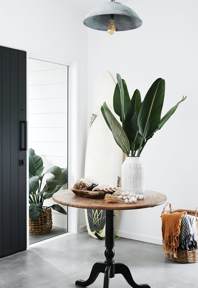 Concrete floors make cleaning up sandy footprints a breeze in [this beach house on the Sunshine Coast](https://www.homestolove.com.au/renovated-beach-house-sunshine-coast-22148|target="_blank"). The 'formal' entry is defined by an accent door painted in Resene Black.