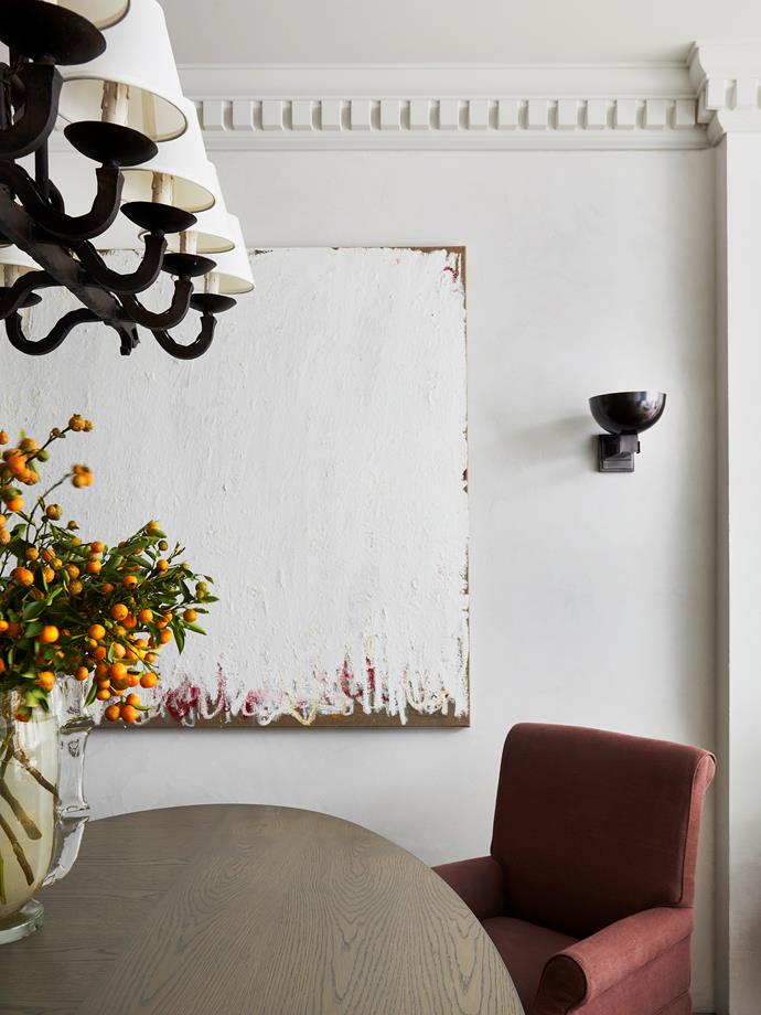 Walls throughout the ground floor are in a specialty marmorino finish. A Spanish forged-iron light fitting from The Vault Sydney hangs above the dining table. The table and chairs were the client's existing pieces and designer Phoebe Nicol of Phoebe Nicol Interior Architecture re-covered the chairs in a Dominique Kieffer linen. Murano vase from The Vault Sydney. Artwork by Jenny Topfer from Fox Jensen.
