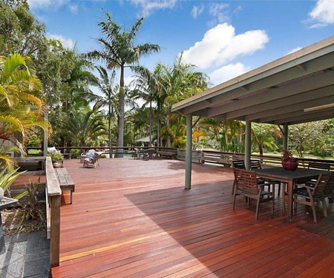 A large deck at the resort is surrounded by a tropical garden.
