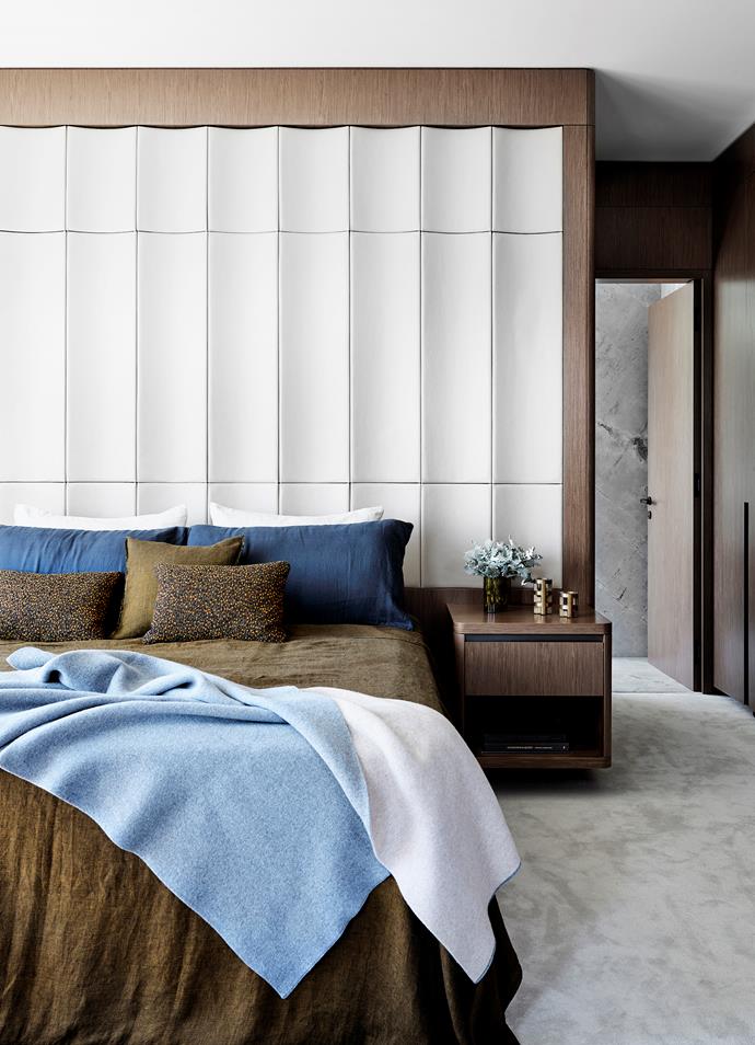 A bedhead wall covered with leather from Pelle Leathers is paired with earthy tones in the Francalia bed linen, custom cushions in Kvadrat fabric by Raf Simons from Cult and built-in side tables in Eveneer 'Even-Mink' from Elton Group. Candleholders from Hub.