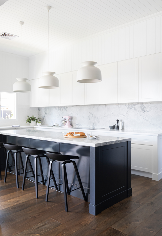 Sleek surfaces allow the kitchen island (in two-pac polyurethane in Dulux Domino) to be the hero in [this renovated Queenslander](https://www.homestolove.com.au/modern-hamptons-style-queenslander-22285|target="_blank"). The natural stone benchtop that echoes the splashback's grey tones.