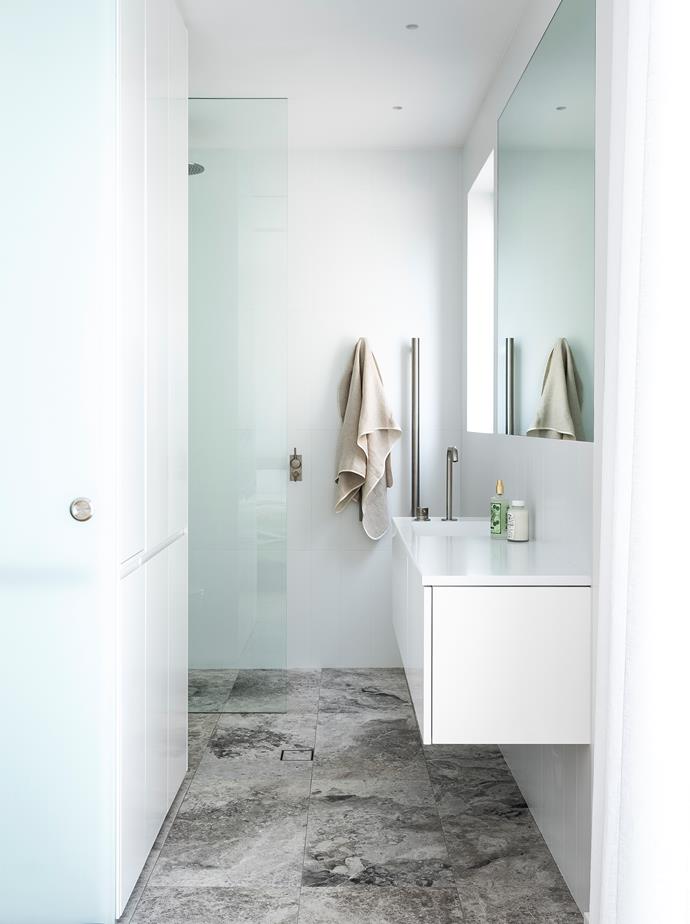 Bathroom walls are covered in matt-white tiles from Bettertiles and paired with Manhattan limestone flooring from Sareen Stone.