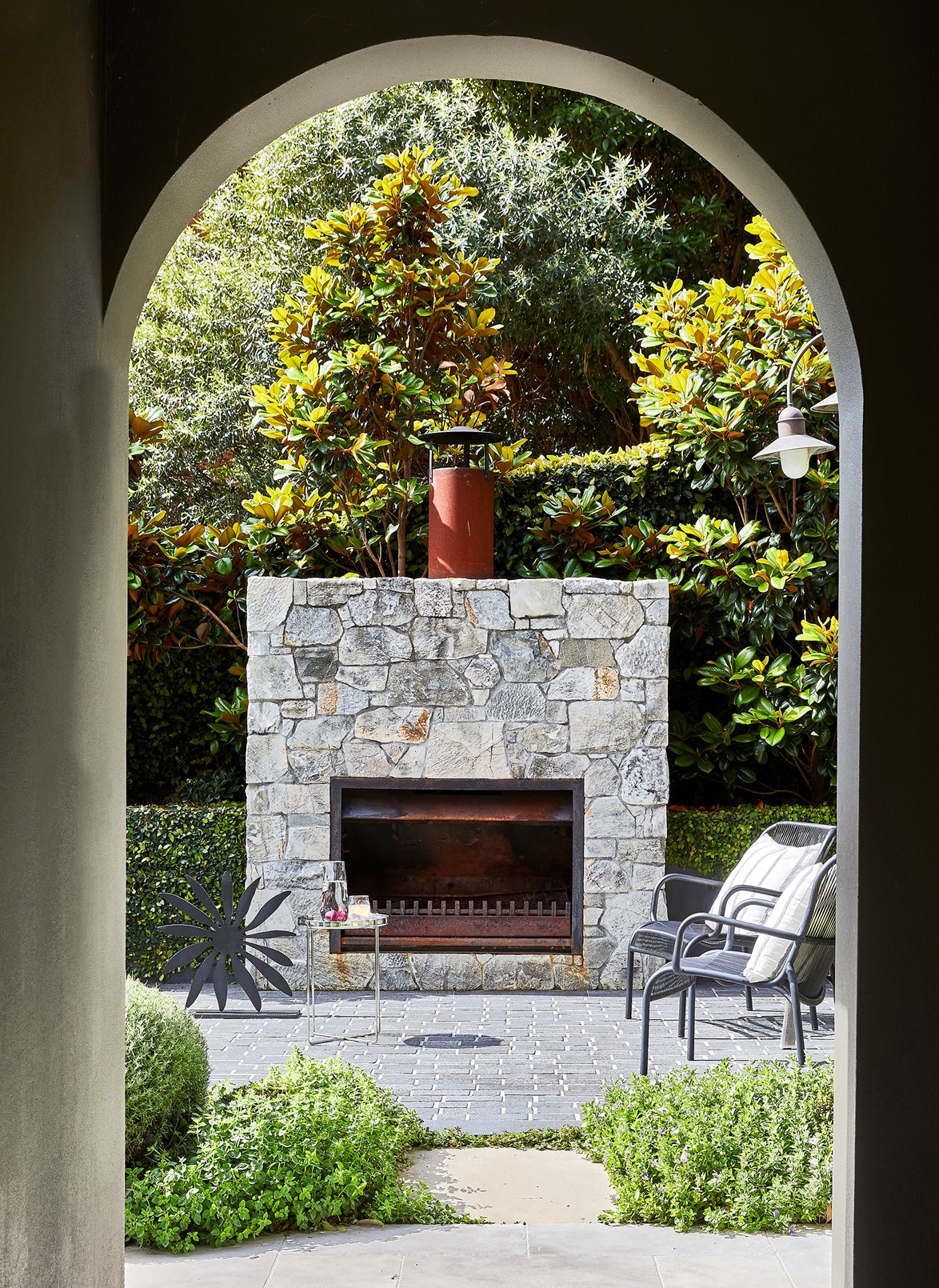 A view to relaxation with [this formally landscaped garden](https://www.homestolove.com.au/bayside-home-palazzo-design-22322|target="_blank") with a feature stone fireplace. With enough planning at the beginning of a project, or a good eye for detail down the track, vistas such as this can be created to connect the indoors with the outside to enjoy the best of both worlds.