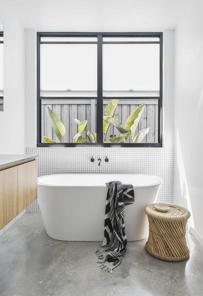 Generous steel-framed windows are the hero in the bathroom of this [Palm Springs style home](https://www.homestolove.com.au/palm-springs-inspired-home-19646|target="_blank"). The polished concrete floor is paired with a timber vanity echoing materials palette of the rest of the home while the freestanding bath tub is nestled perfectly beside the window to help make the most of natural light.<br><br>