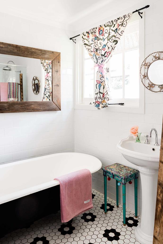 Like the rest of this colourful grandmillenial [pink cottage in Toowomba](https://www.homestolove.com.au/grandmillennial-pink-cottage-22384|target="_blank"), QLD, the bathroom is filled with personality, pattern and print. A clawfoot bath and subway tiles make for the perfect pairing with vintage finds.