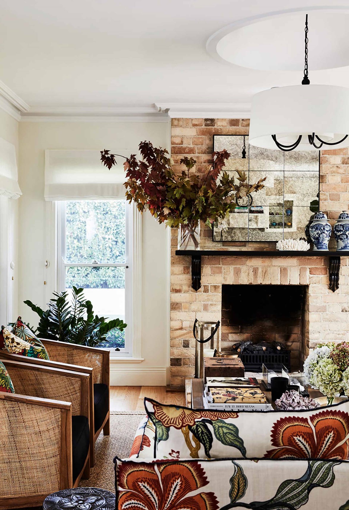 There's no question the fireplace is the star of the show in [this charming weatherboard cottage](https://www.homestolove.com.au/charming-weatherboard-cottage-in-berry-20329|target="_blank"). Scale is everything here, as the rattan tub chairs tie into stone textures and the simple mantle is a stage for styling simple vignettes. The antiqued mirror refects more stone in the wall opposite.