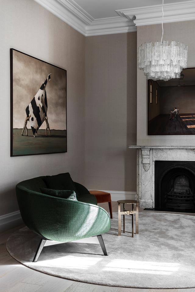 The sitting room, also referred to as the 'cocktail room', in this [updated Edwardian abode](https://www.homestolove.com.au/edwardian-house-modern-revamp-22417|target="_blank") has been softened by a silver-grey rug and linen wallpaper, with its original cornices and heritage marble fireplace kept firmly intact.