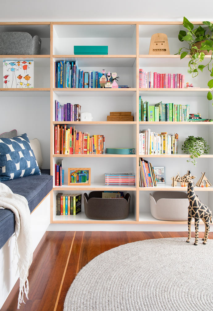 The library has floor-to-ceiling shelving and comfy day beds by Berkeley Interiors, with books grouped to create blocks of colour that tie in with accessories.