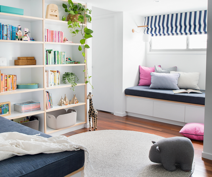 Contemporary kids play room with built-in seating and colour-coordinated bookshelf