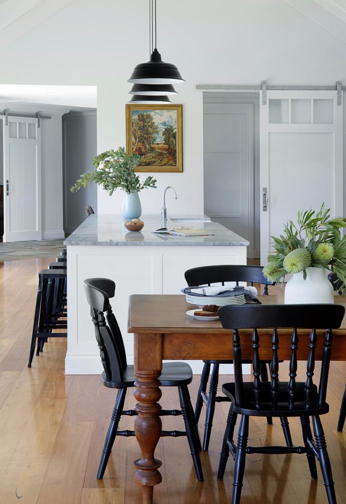 Other great second-hand finds include a 30-year-old solid timber dining table and farmhouse chairs repainted in Dulux Night Sky. They sit well in a timeless design that features a [kitchen island](https://www.homestolove.com.au/8-kitchen-islands-to-inspire-your-next-kitchen-renovation-5686|target="_blank") topped with Super White Quartzite, also from Mar Gra, and Brodware 'Winslow' tapware. The artwork above Eleia was a gift, and Leanne's grandmother created the other work.