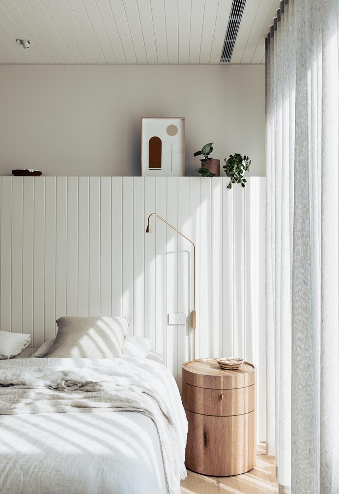 Curves and linear elements play a starring role in this bedroom. Luxurious, ceiling to floor curtains let dapped light through, which drenches the soft linens and textures of the bed. The pared-back palette was a deliberate choice, letting the home's [Mornington Peninsula views](https://www.homestolove.com.au/contemporary-coastal-home-victoria-22859|target="_blank") take centre stage.