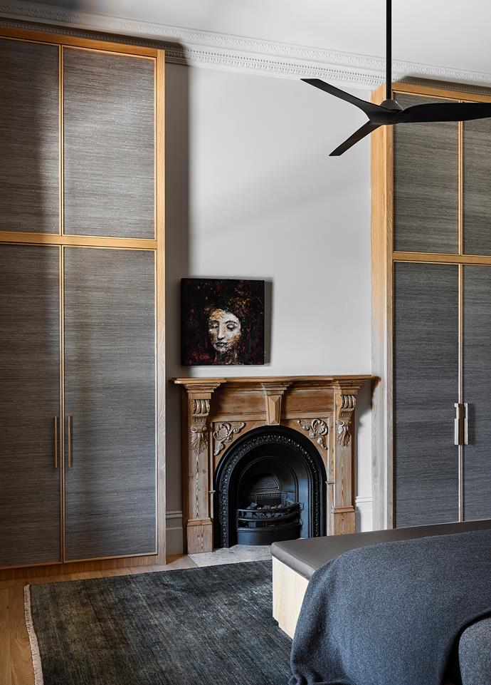 In bedroom two, an artwork by Tracy Sharp hangs above the fireplace between wardrobes with oak frames and inserts of Phillip Jefferies 'Juicy Jute' grasscloth from The Textile Company. Merino blanket from Bemboka. 'Egyptian' rug in Aegean from Armadillo.