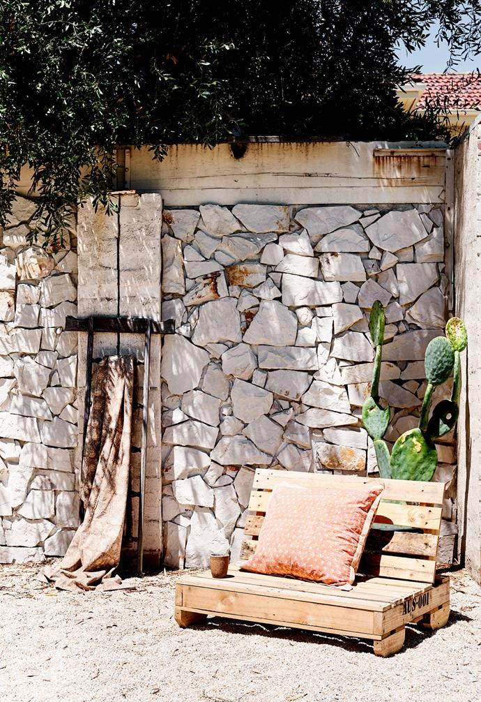 Outside, Mediterranean style continues with Blanca Free Form stone cladding from Tiles of Ezra, alongside a pallet chair finished with an At Home With Georgia Ezra cushion.