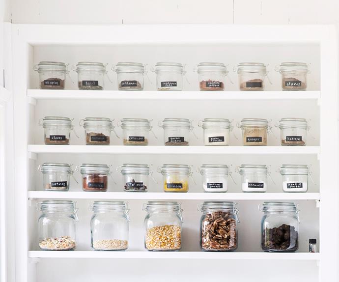 Spices stored in labelled Mason jars on a pantry shelf