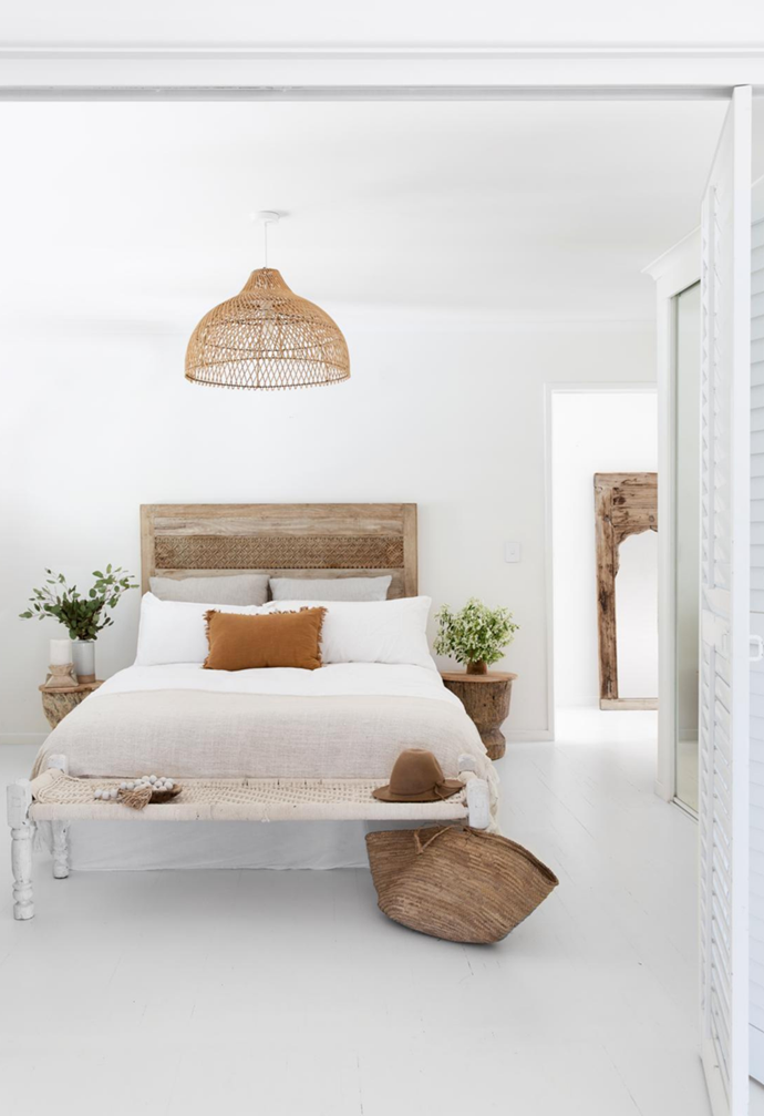 The natural fibres and white theme of this [coastal Noosa home](https://www.homestolove.com.au/white-on-white-coastal-home-noosa-22415|target="_blank") is continued throughout the bedrooms with white linen bedding and timber stump bedside tables.