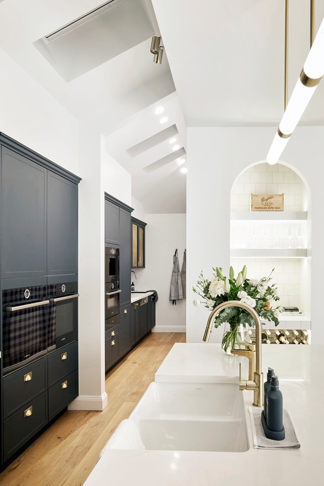 In the 2021 season of *The Block* Kirsty and Jesse made the most of hidden spaces with a butler's pantry continuing directly in line with their Hamptons-style [open plan kitchen](https://www.homestolove.com.au/kirsty-and-jesse-house-the-block-2021-23107|target="_blank"). The clever layout keeps the main kitchen compact, while a second sink and bank of appliances allow for hard work to carry on behind the scenes. Skylights let in loads of natural light and Kirsty's choice of a bold gingham wallpaper makes a sneaky statement.