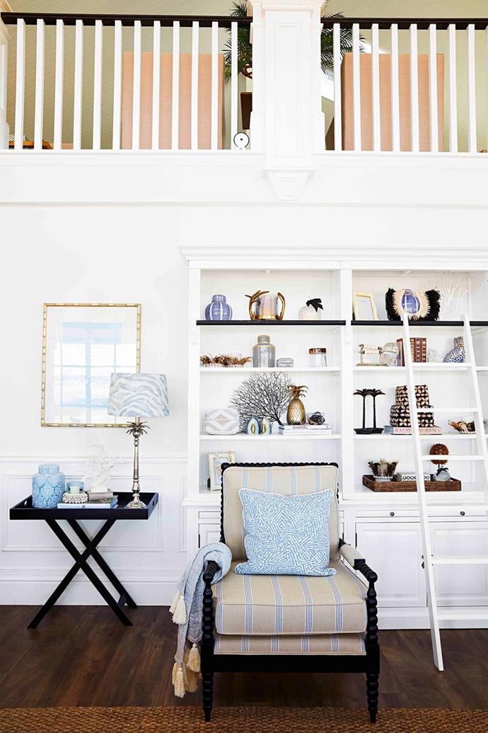 Library shelving, complete with a ladder, provides tiered surfaces to curate collections and create eclectic vignettes in this incredible [Hamptons-inspired farmhouse](https://www.homestolove.com.au/grand-hamptons-country-farmhouse-22797|target="_blank"), with wainscotting along the walls. 