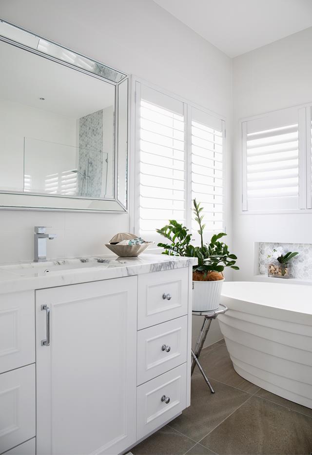 Plantation shutters allow filtered light into the main bathroom of this [riverfront Hamptons inspired home on the Gold Coast](https://www.homestolove.com.au/riverfront-hamptons-home-gold-coast-22488|target="_blank"). 