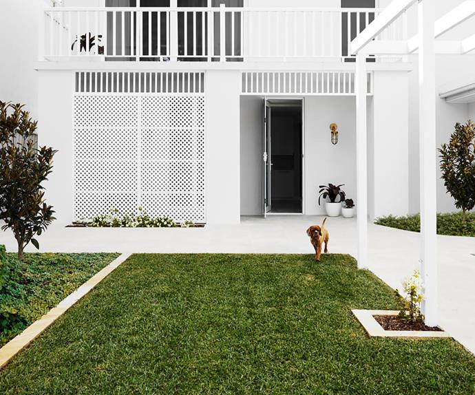 White Hamptons style home exterior with manicured lawn