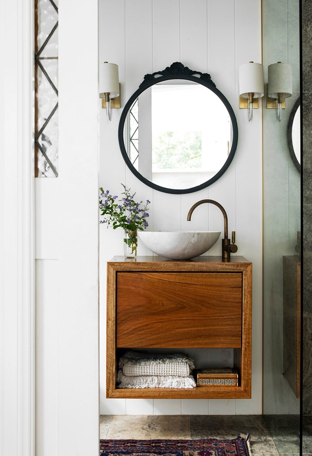 **Unique touches**<br>
Bespoke, heirloom and store-bought pieces transform simple into special. The spotted gum vanity in [this ensuite](https://www.homestolove.com.au/exotic-coastal-home-central-coast-23065|target="_blank") was made by homeowner Nicole's builder and finished with modern tapware and round stone sink. The wall sconces are new, while the vintage mirror has been updated with black paint. The mat is a handwoven silk carpet from Austria. "It's been in my family for more than 100 years," says Nicole.