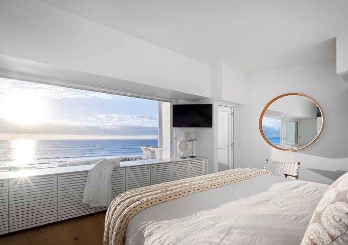 Whites and sandy tones prevail in the main bedroom where everything is oriented to that view. Custom slat-fronted cabinetry.