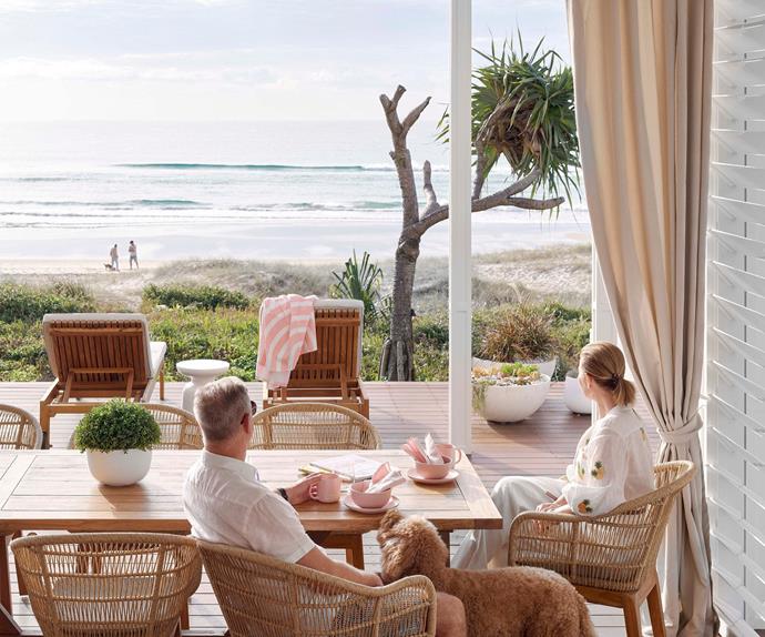 Couple sitting at dining table overlooking beach on the Gold Coast, QLD