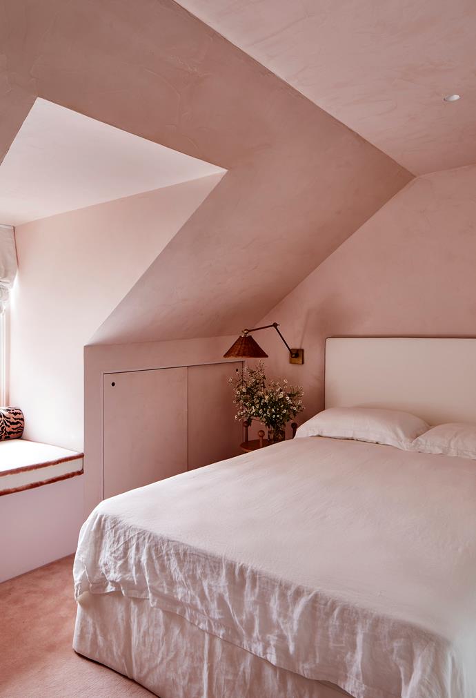 Walls in the charming guest bedroom of this [elegant Sydney home with French-inspired interiors](https://www.homestolove.com.au/elegant-home-french-inspired-interior-sydney-22184|target="_blank") are in a custom waxed-pink stucco by Porter's Paints. Custom bedhead by interior designer Phoebe Nicol.