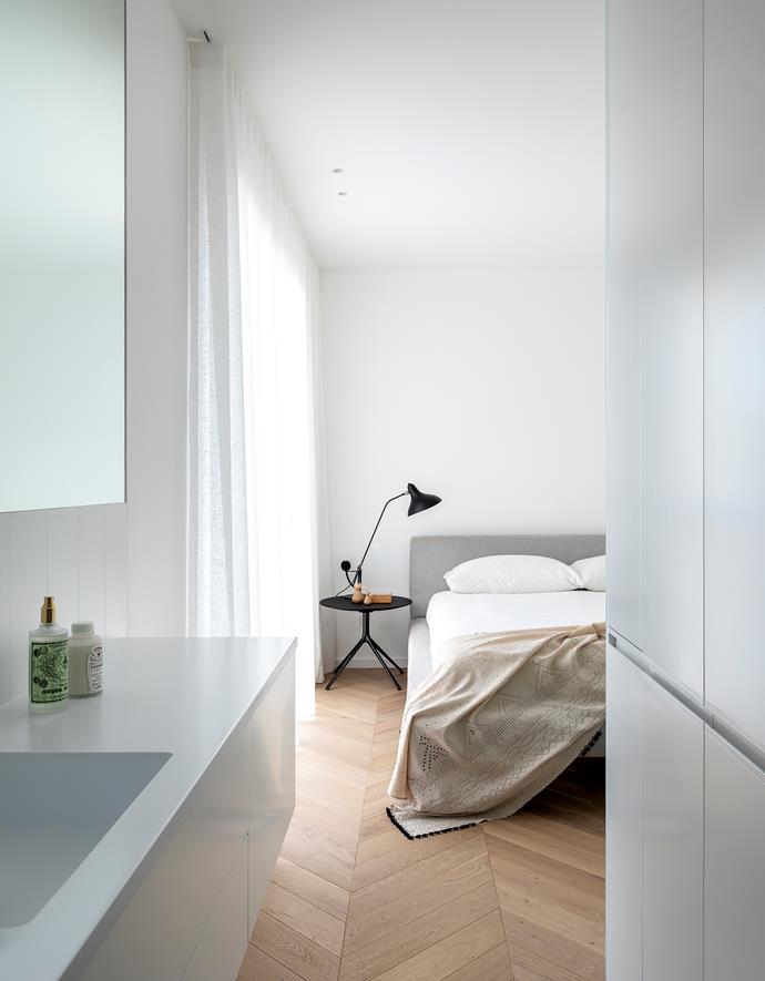 In the master bedroom in this [minimalist Sydney apartment](https://www.homestolove.com.au/black-and-white-apartment-sydney-1-22289|target="_blank"), a 'Mondrian' bedside table from Poliform accompanies a B&B Italia 'Charles' bed from Space. DCW Éditions 'Mantis BS3' table lamp and Injiri Meghwal throw, both from Spence & Lyda.