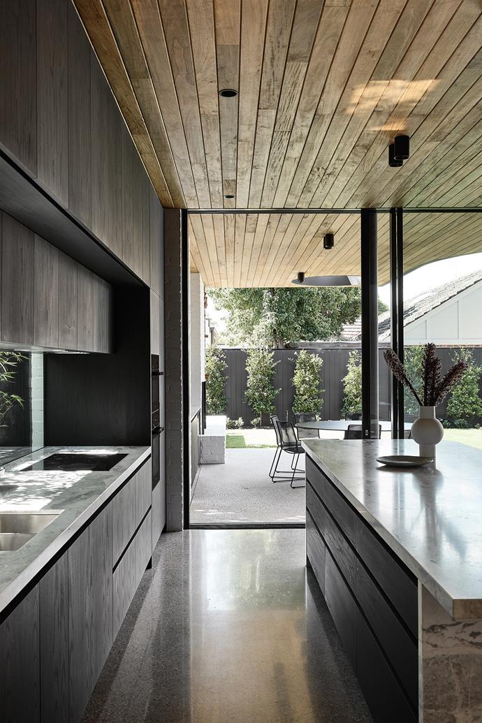The kitchen enjoys a seamless connection with the loggia. On the benchtops is Elba stone from [CDK Stone](https://www.cdkstone.com.au/|target="_blank"|rel="nofollow"). The timber-veneer joinery is finished in Cutek Black Ash oil.