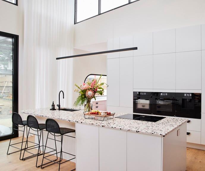 White kitchen with high ceilings and terrazzo island bench