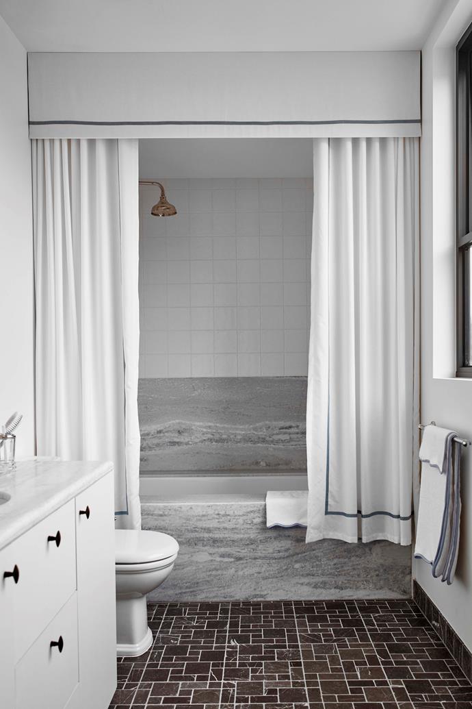 The first floor bathroom features textured Pietra Grey limestone mosaic floor tiles.