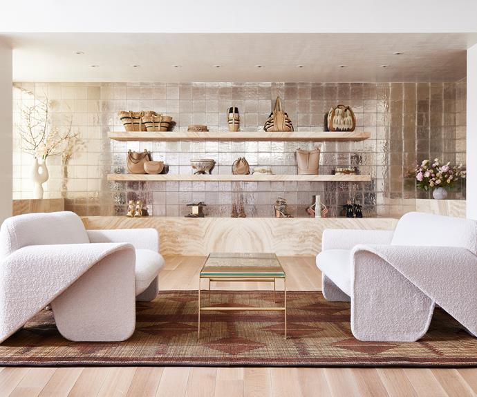 A smaller lounge area is outfitted with vintage Gerard Lange for De Sede sofas in Dedar boucle wool, a glass and bronze coffee table and a Tuareg leather and bamboo rug. Ulla's accessories are displayed on [travertine benches](https://www.homestolove.com.au/travertine-tiles-ideas-22812|target="_blank") against Italian handmade gilt mirror tiles from Sicis.