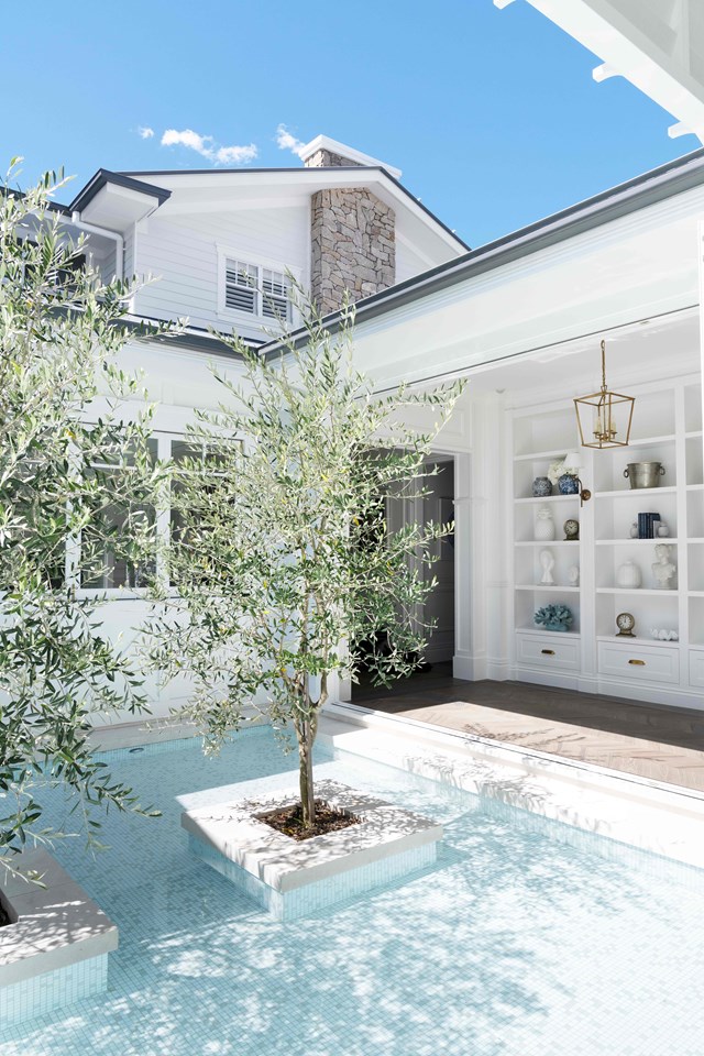The owners of this [family oasis on the Sunshine Coast](https://www.homestolove.com.au/hamptons-christmas-home-23131|target="_blank") had a unique opportunity to design their swimming pool from scratch to wrap around the home layout. The result is a breathtaking garden within the swimming pool that can be seen from this breezeway.