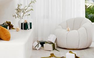White armchair surrounded by Christmas presents