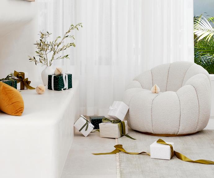 White armchair surrounded by Christmas presents