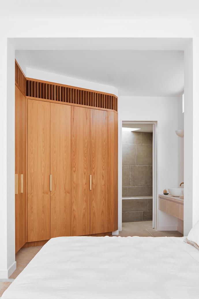 The bedroom features a custom wardrobe in oak with brass pulls.