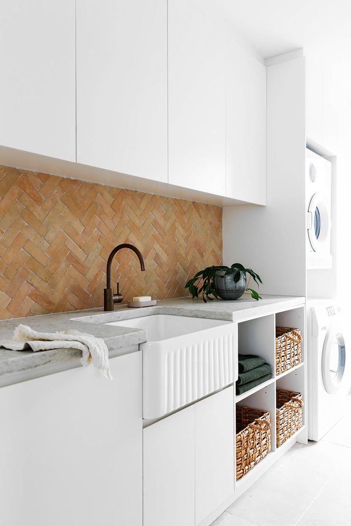 The laundry features a terracotta splashback from Tiles By Kate and a sink from Schots Home Emporium.