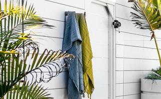 blue and green turkish towel hanging next to our outdoor shower
